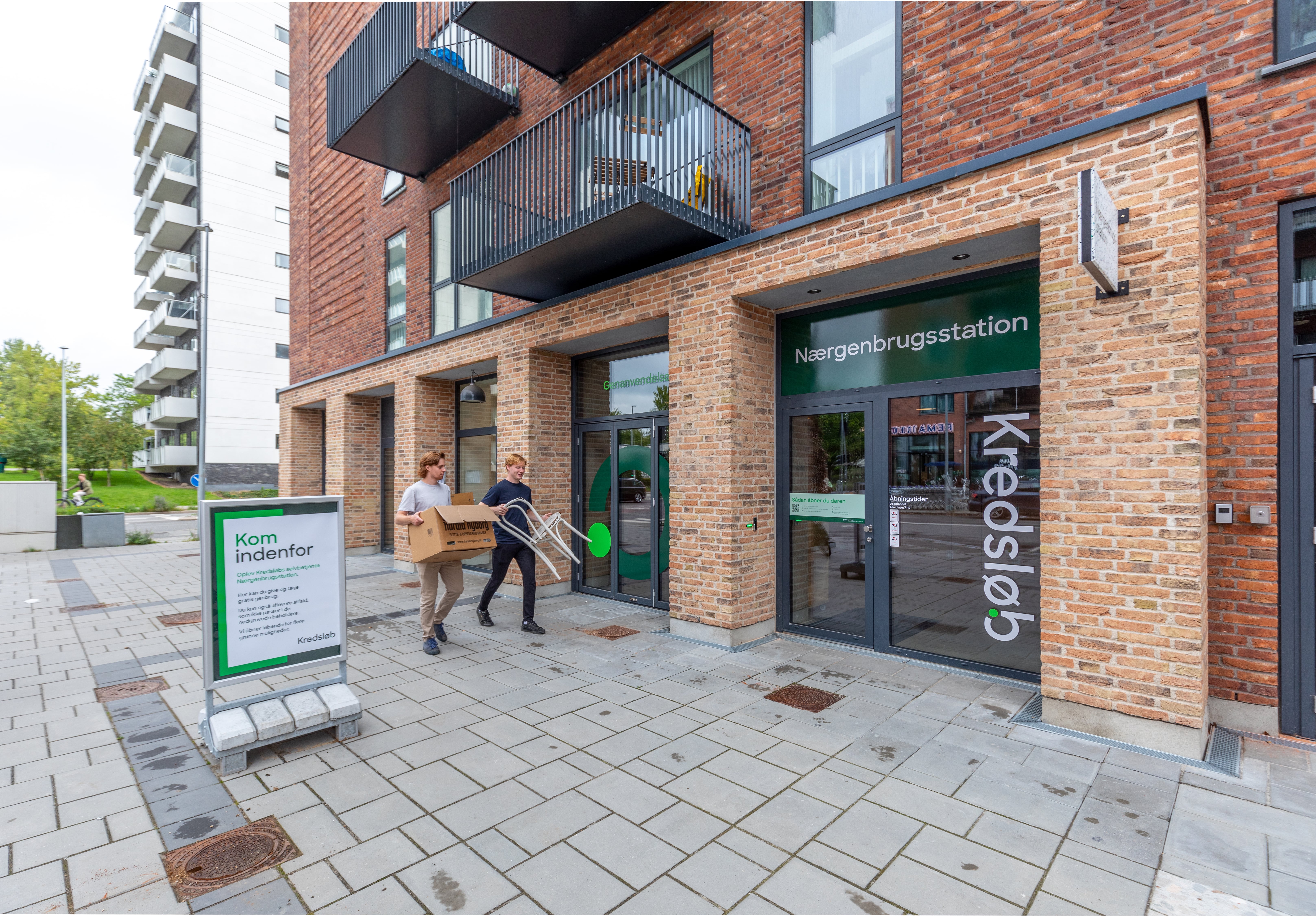 2 unge mennesker bærer genbrugsting til nærgenbrugsstationen 2 unge mennesker bærer genbrugsting til nærgenbrugsstationen